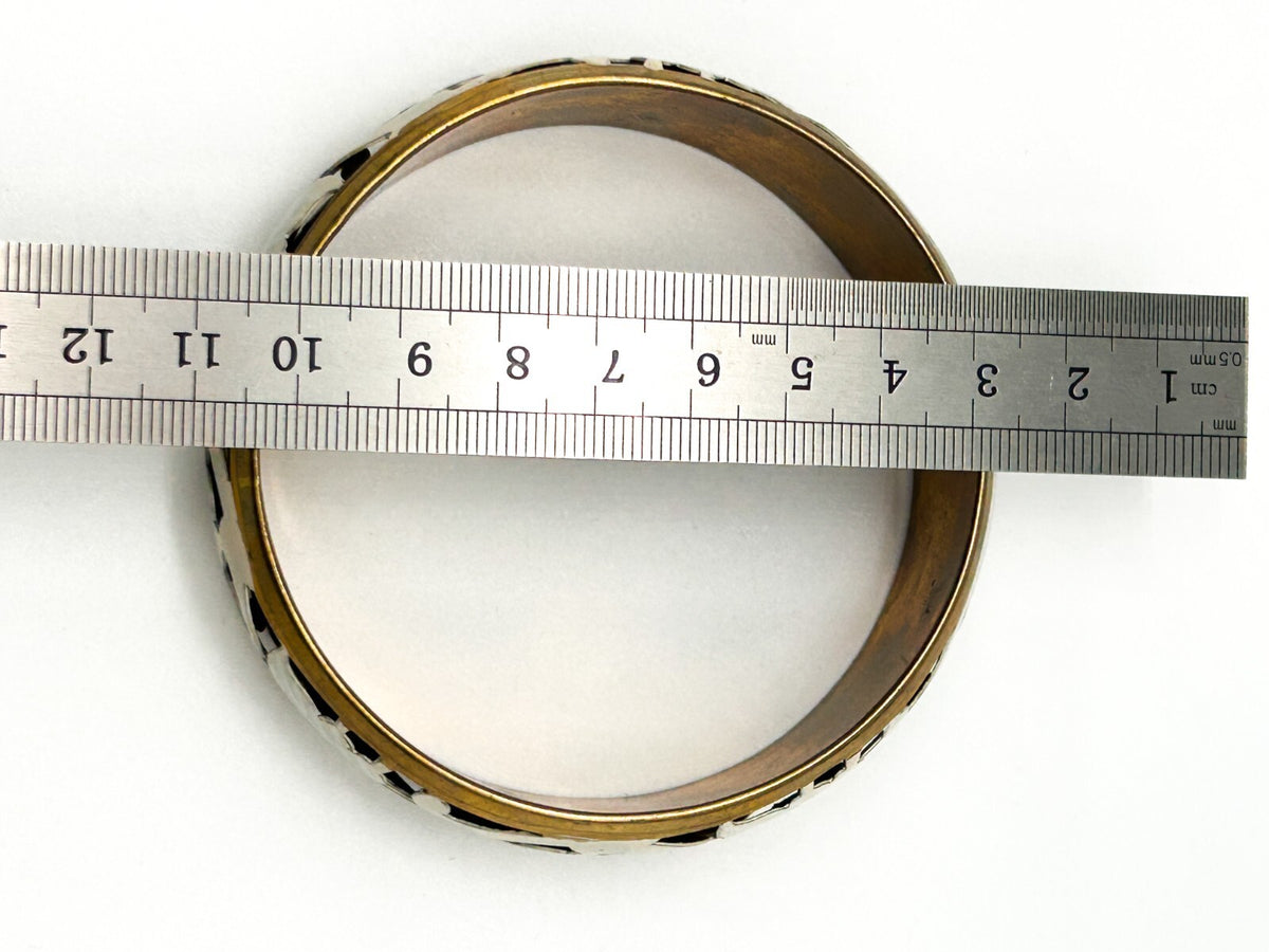 Brass tone bangle with white floral openwork metal design