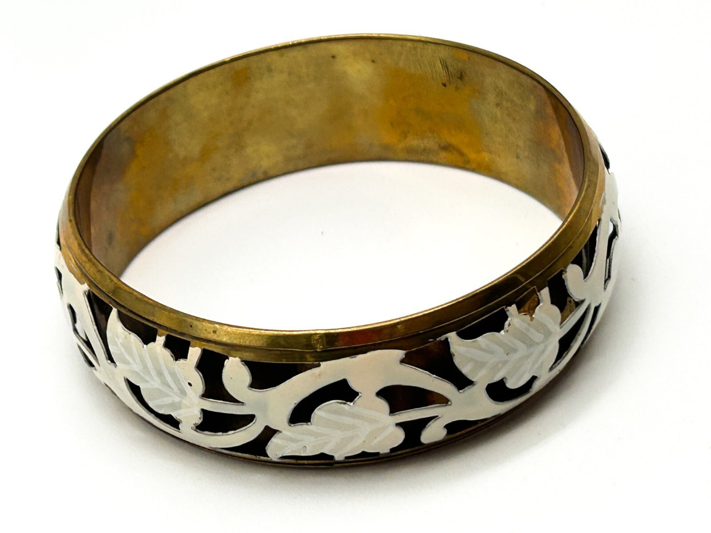 Brass tone bangle with white floral openwork metal design