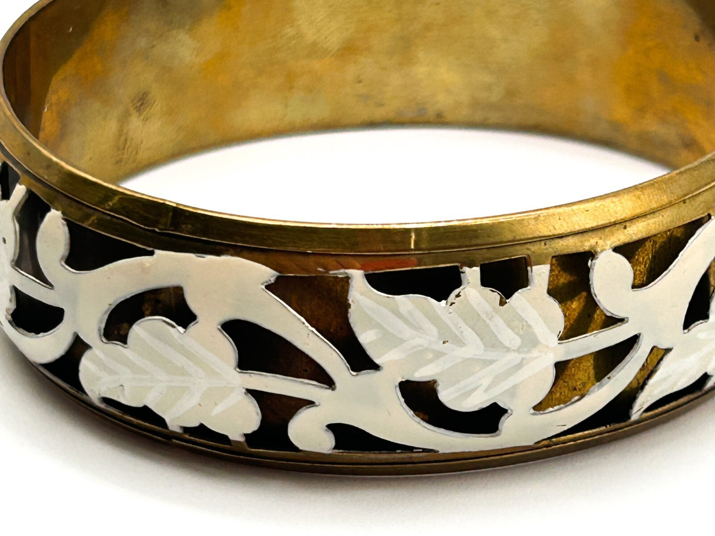 Brass tone bangle with white floral openwork metal design